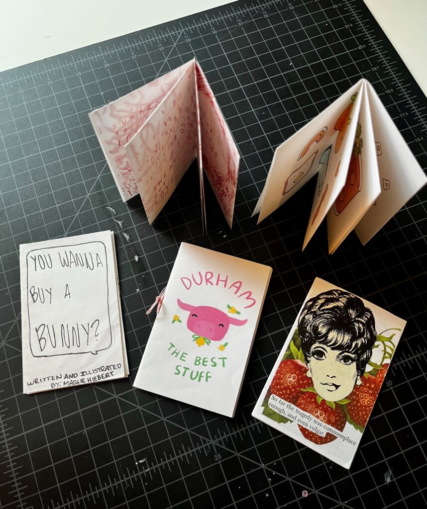 Five small zines (folded paper magazines) arranged on a surface