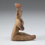 A photo of an Olmec style ceramic seated figure