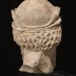 A picture of an ancient ceramic statue head with a large beard