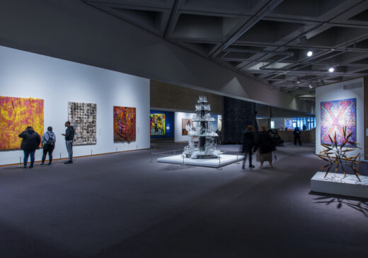 A photograph of a darkly lit museum gallery