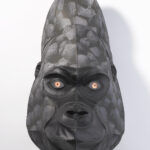 A gorilla head sculpture made from stitched black leather and paper