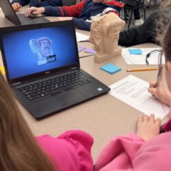 Two students look at an image on a laptop