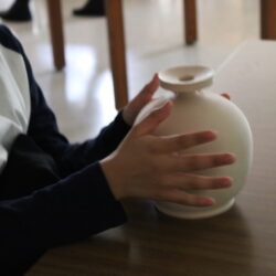 Student's hands holding a white 3D printed object
