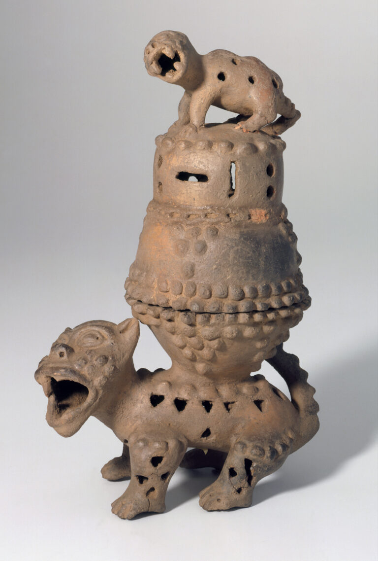 A ceramic incense burner with two separate pieces: a perforated animal-shaped base and a stacked, pierced lid topped by a small crouching creature.
