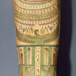 Egyptian wooden coffin with a carved face, striped headdress, and body covered in painted designs of hieroglyphs, figures, and symbols.