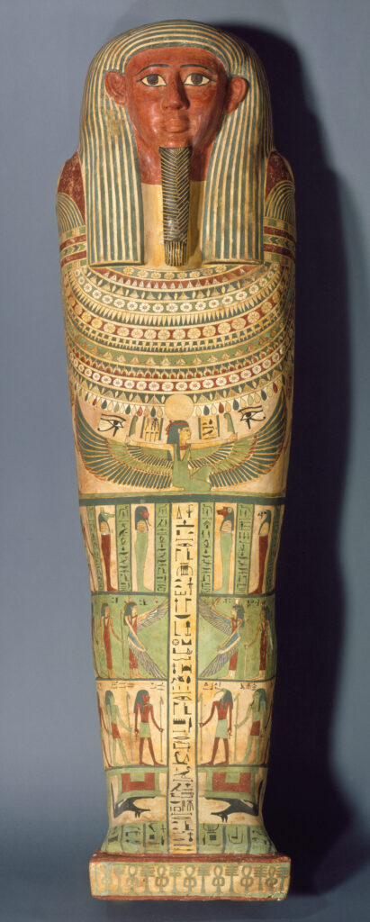 Egyptian wooden coffin with a carved face, striped headdress, and body covered in painted designs of hieroglyphs, figures, and symbols.