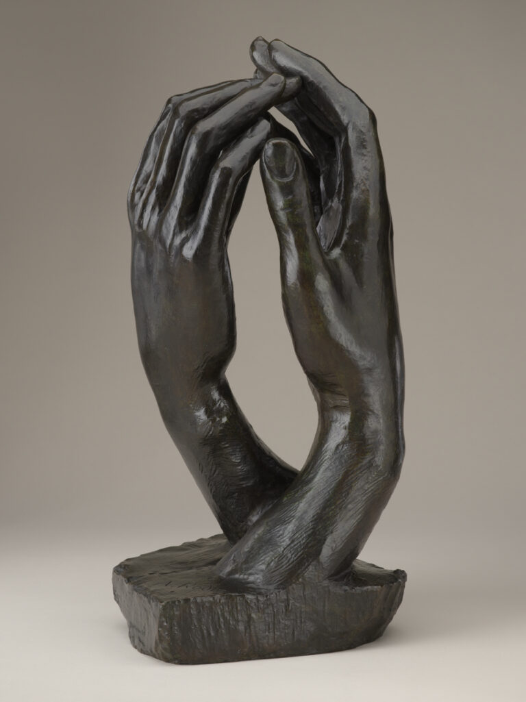 Bronze sculpture of two right hands facing each other with fingertips touching.