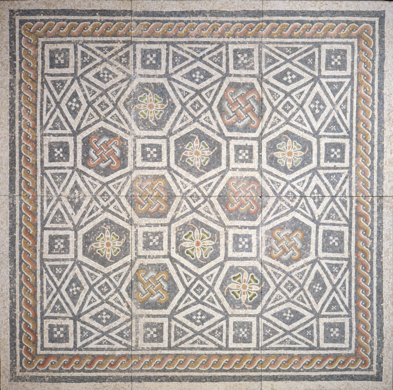 Square mosaic floor made of white marble pieces and colored glass, organized to create floral desgins and geometric patterns.