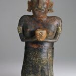 A ceramic figure of a woman holding a cup in both hands and wearing jewelry and a skirt.