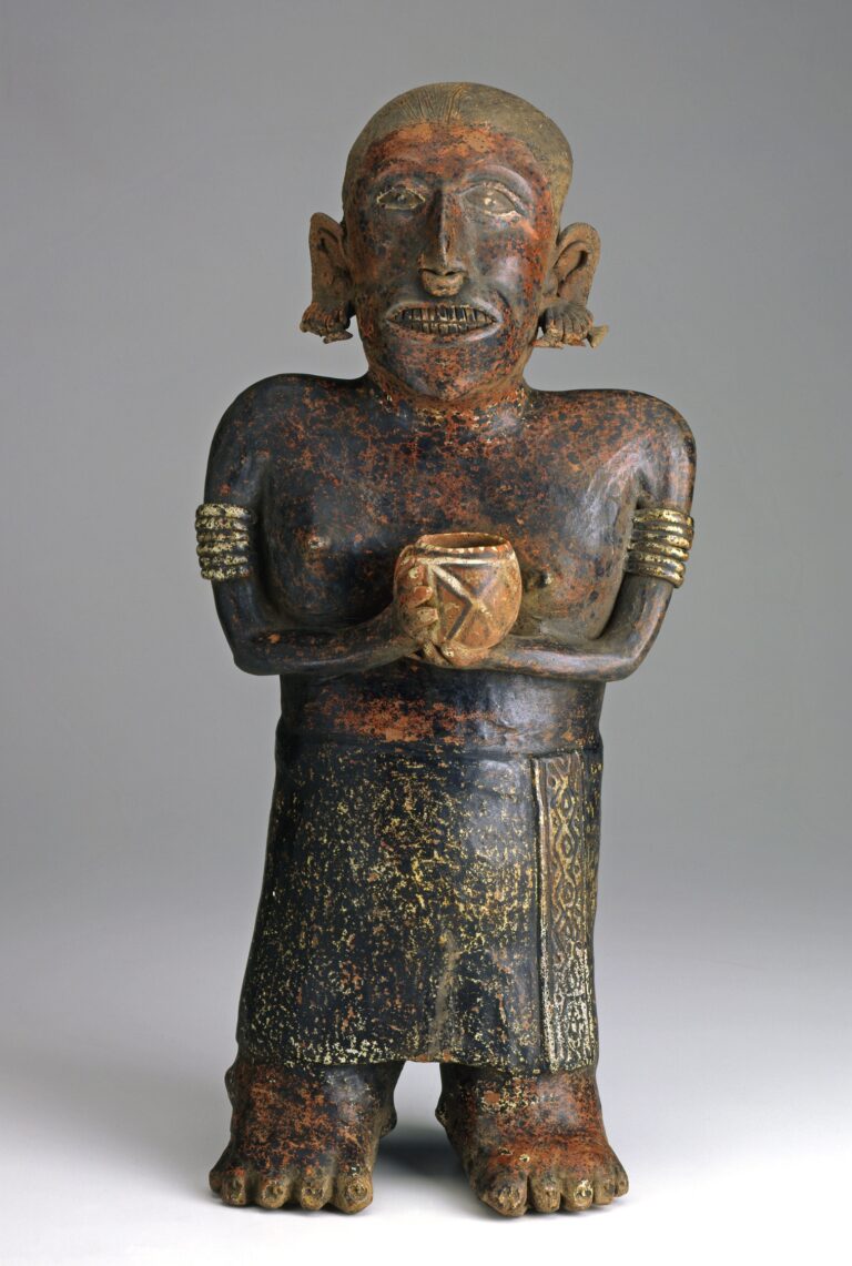 A ceramic figure of a woman holding a cup in both hands and wearing jewelry and a skirt.